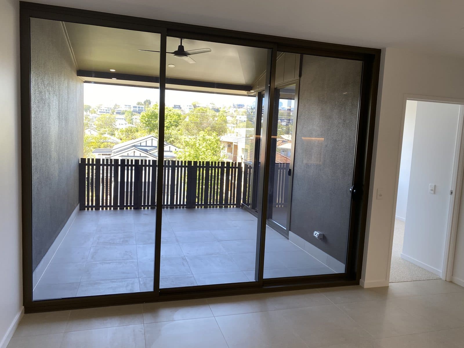 Balcony — sliding doors with ceiling fan and district views