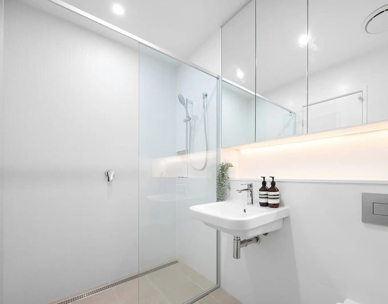 Ensuite — frameless shower, mirrored cabinetry and Aesop amenities