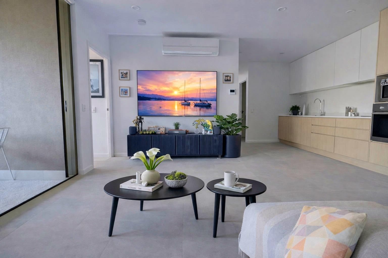 Open plan living — entertainment unit, coffee tables and kitchen beyond