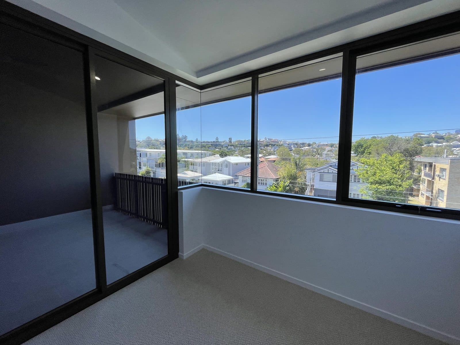 Master bedroom — mirrored walk-in robe and panoramic windows