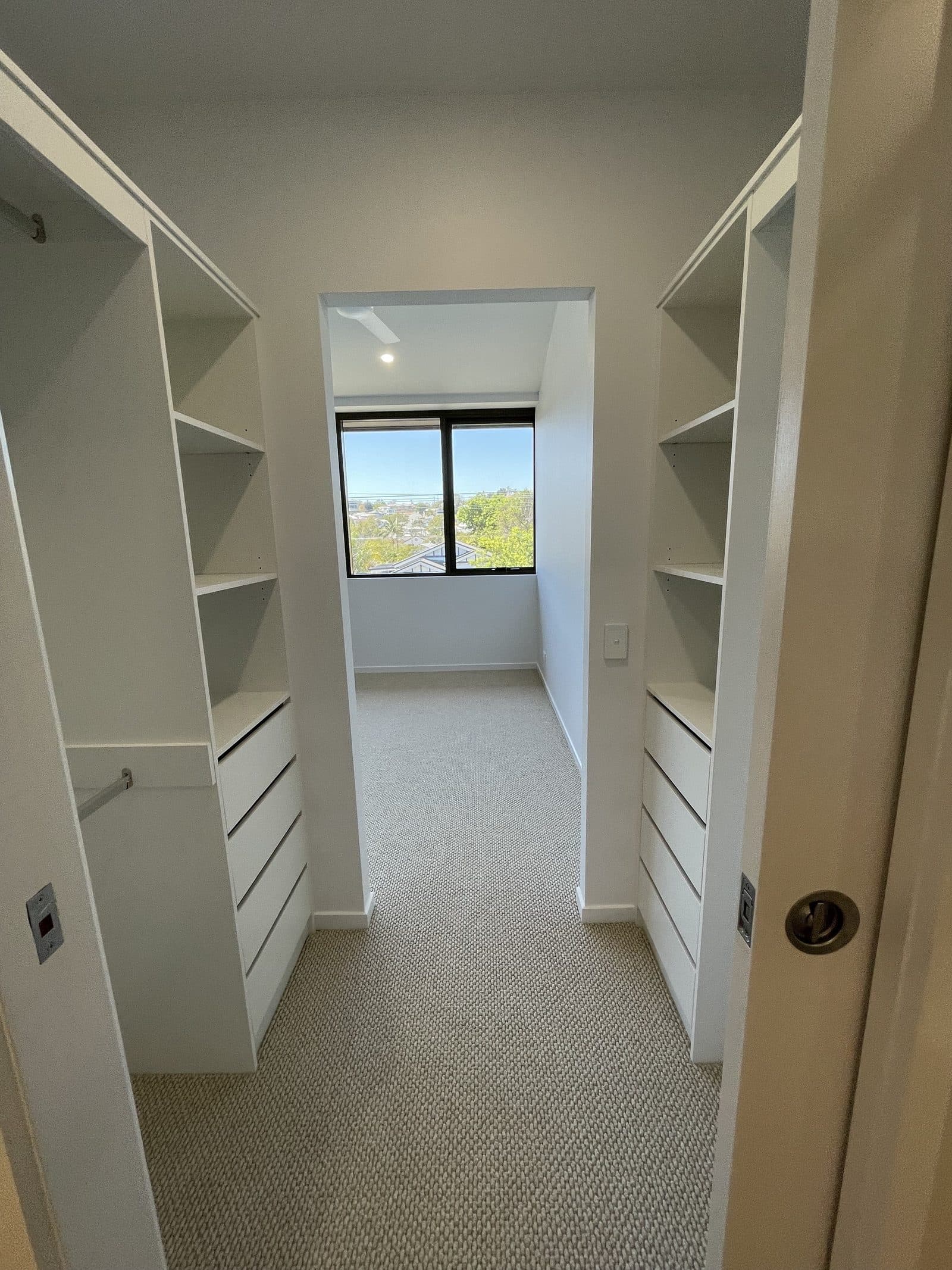 Walk-in robe with built-in shelving, drawers and window